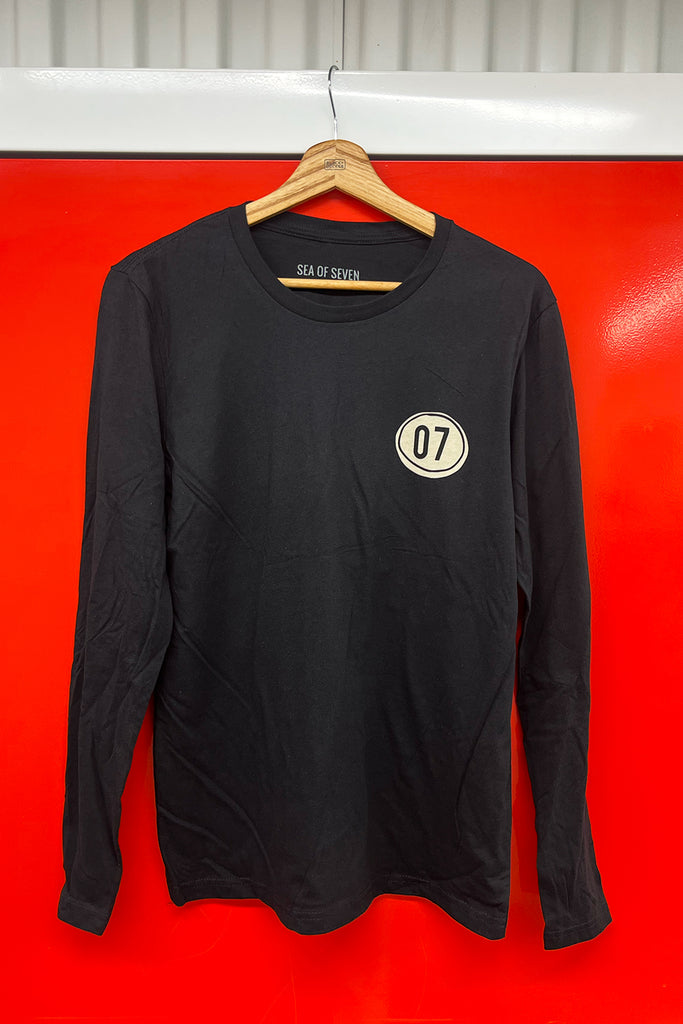 Black long-sleeve shirt with a 07 logo on a hanger against a red background