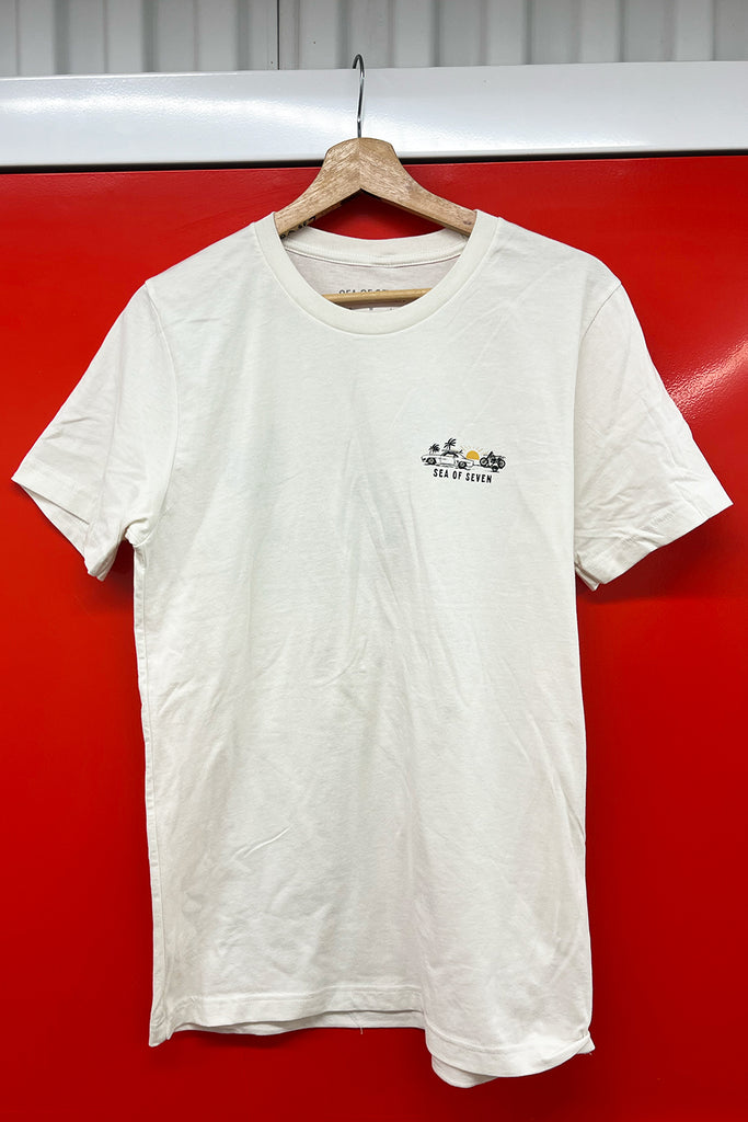 White t-shirt with a logo on a wooden hanger against a red background