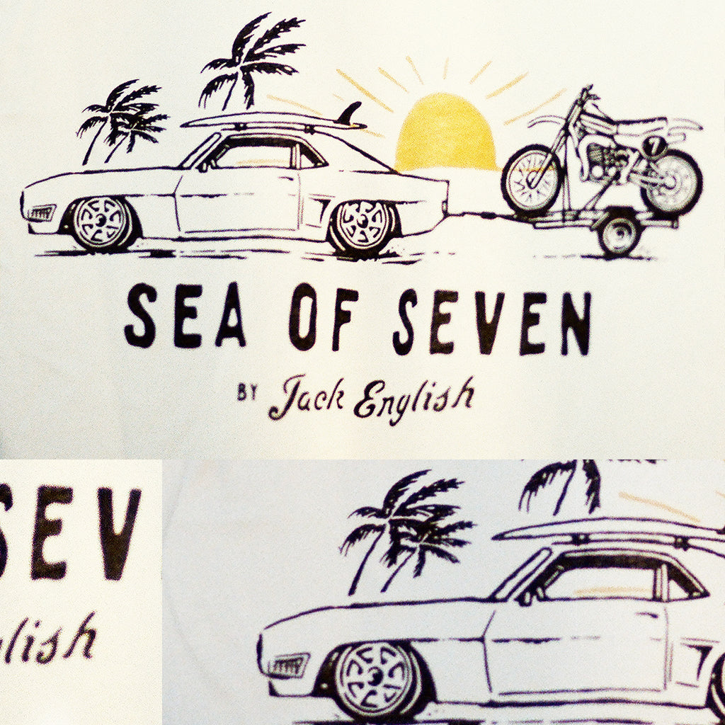 Camaro car with surfboard towing a motorcycle